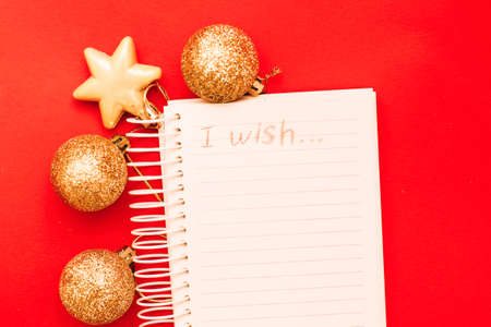 Gold Christmas balls and toys with empty blank note sheet on a red background.の写真素材