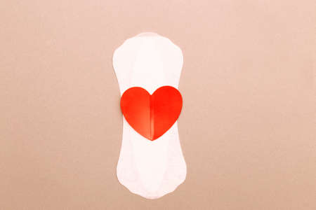 Feminine sanitary pad with a red heart on pink background.の写真素材