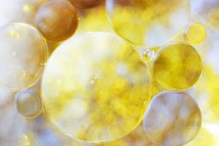 Gold Oil bubbles close up. circles of water macro. abstract shiny yellow backgroundの写真素材