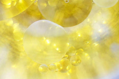 Gold Oil bubbles close up. circles of water macro. abstract shiny yellow backgroundの写真素材