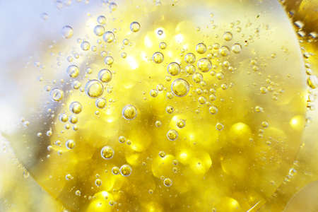 Gold Oil bubbles close up. circles of water macro. abstract shiny yellow backgroundの写真素材
