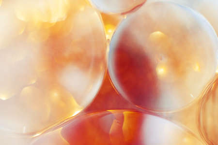 Oil bubbles close up. circles of water macro. abstract orange and fiery red backgroundの写真素材