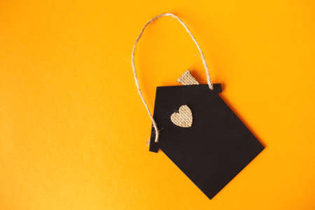 Little toy house made of chalk board on a orange backgroundの写真素材