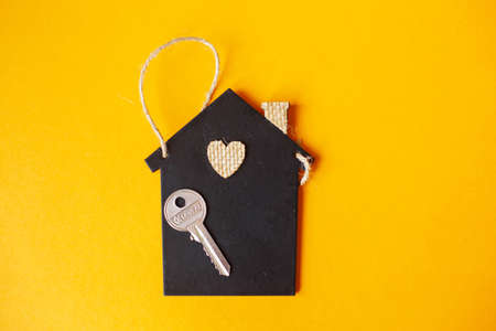 Little toy house with a key on a orange backgroundの写真素材