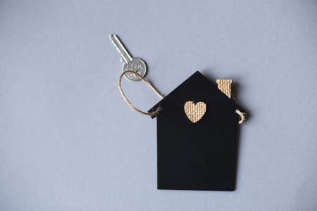 Little toy house with a key on a gray backgroundの写真素材