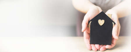 womans hand holding little toy house. Home insurance concept.の写真素材