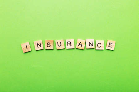 inscription insurance on a green background made by wooden blocks.の写真素材