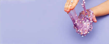 Making slime at home. child holding and stretching colorful slime. DIY concept. bannerの写真素材