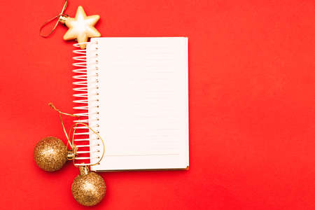 Gold Christmas balls and toys with empty blank note sheet on a red background.の写真素材