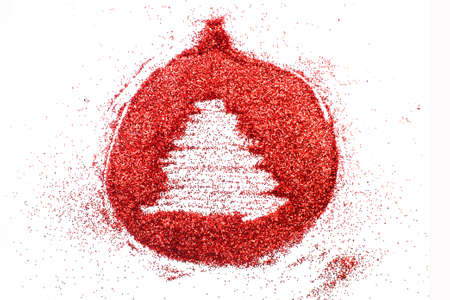 a finger drawn tree on shiny red confetti background. christmas toy ballの写真素材