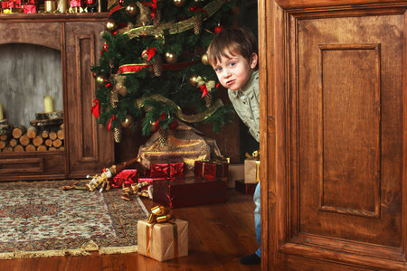 child peeking from behind the door of the giftの写真素材