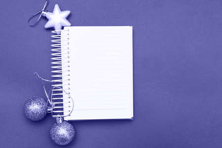 Christmas balls and toys with empty blank note sheet on a blue background.