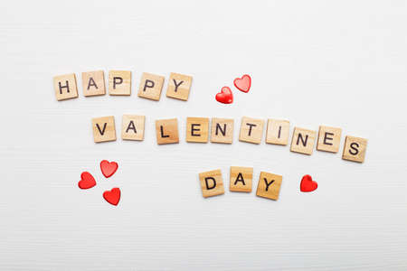 inscription happy Valentine's day with a red heart on a white wooden backgroundの写真素材
