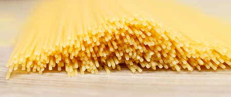 spaghetti yellow background close. raw pasta macroの写真素材