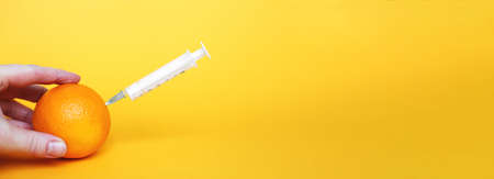 orange fruits with syringe extracting liquid with vitamin C. natural anti aging cosmetics conceptの写真素材