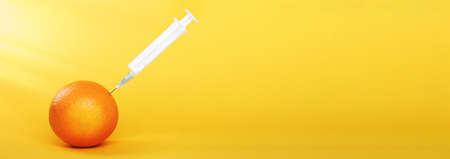 orange fruit with syringe extracting liquid with vitamin C. natural anti aging cosmetics conceptの写真素材