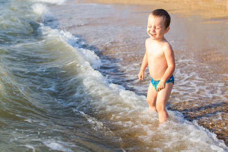 a little boy having fun in the sea on the waves.の写真素材