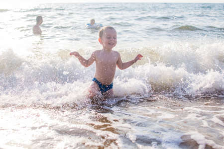 a little boy having fun in the sea on the waves.の写真素材