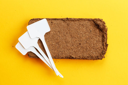 soil texture close up. mock up. coconut briquette with writing boards on a orange background.の写真素材