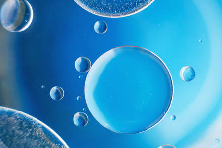 abstract light blue background with oil circles . bubbles of water close up .