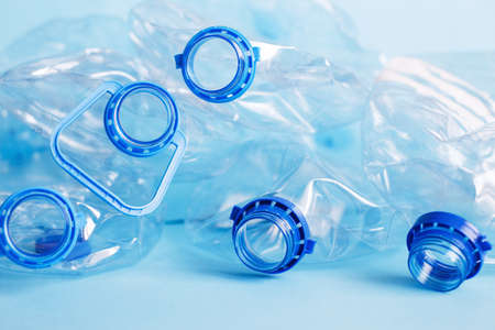 a lot of plastic empty rumpled used bottles on a blue background. waste and pollution concept.の写真素材