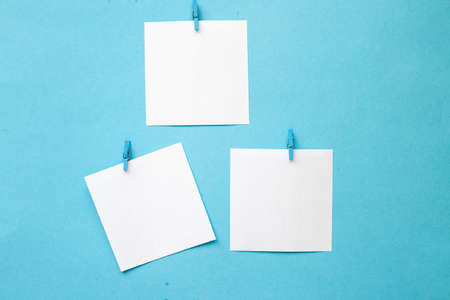 white stickers with empty mockup for your text hanging on pin on blue background. Copy space for textの写真素材