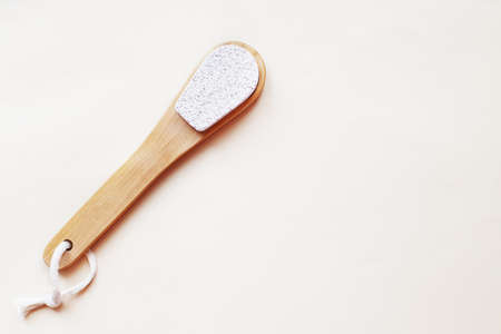 eco friendly foot pumice stone on beige background with copy space. woman legs care concept.