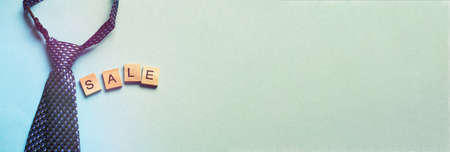 the word sale made by wooden cubes on a blue background with a tie. bannerの写真素材