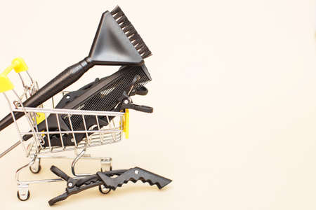various hairdressing tools with shopping cart on a beige background. beauty salon concept.の写真素材