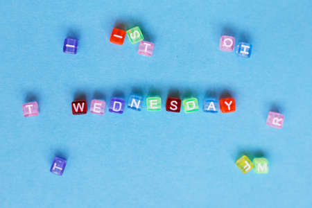 inscription wednesday made by multicolor plastic cubes on a blue backgroundの写真素材
