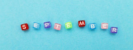 inscription September made by multicolor plastic cubes on a blue background. bannerの写真素材