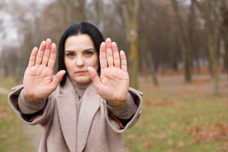 woman stretches her hands with open palms as a stop signの写真素材