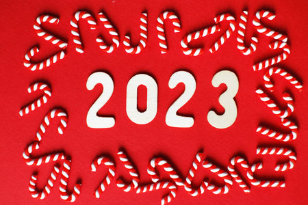 Christmas composition with candy canes and number 2023 on a red background. Copy space for textの写真素材