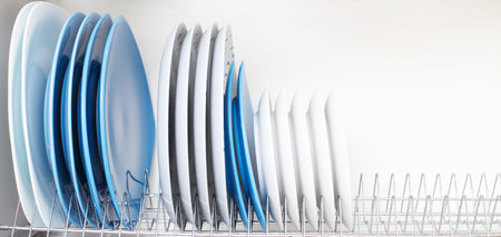 clean dishes stand in a drawer for drying dishes in the kitchen.の写真素材