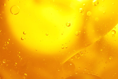 Gold Oil bubbles close up. circles of orange water macro. abstract shiny yellow background.の写真素材