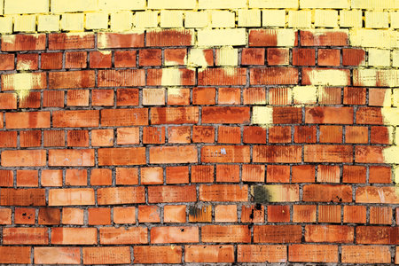 Red grunge brick wall, abstract background texture with old vintage style pattern with yellow paint on top.の写真素材