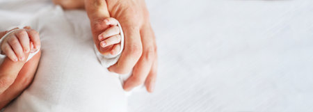 Close up photo of father holding baby hand. New family, care, love and baby protection concept. Bannerの写真素材