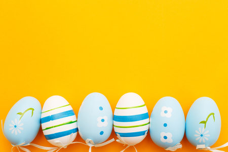 easter colorful handmade painted blue eggs on orange background with copy space.の写真素材