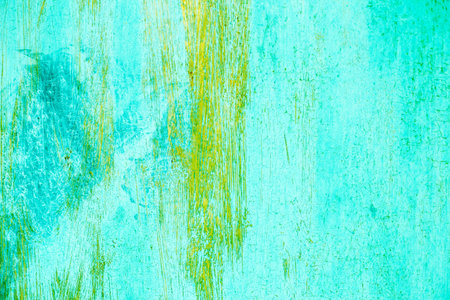 Rusty turquoise green and yellow metal abstract background. Texture of an old grunge metal plate with cracked paint. Rusted painted wall.の写真素材