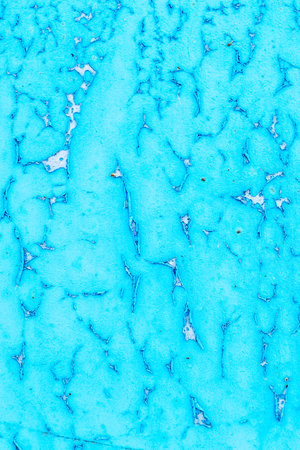 Old blue turquoise paint peeling from concrete or metal wall background. Texture of an old grunge plate with cracked paint with a hole.の写真素材
