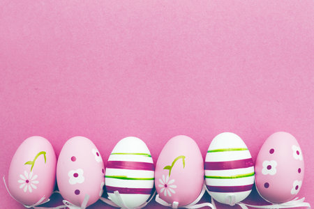 easter colorful handmade painted eggs on pink background with copy spaceの写真素材