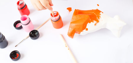 a little girl paints a toy fox made of clay. DIY conceptの写真素材