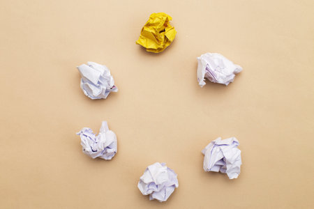 crumpled yellow and white paper as a concept creative idea and innovation on a beige background