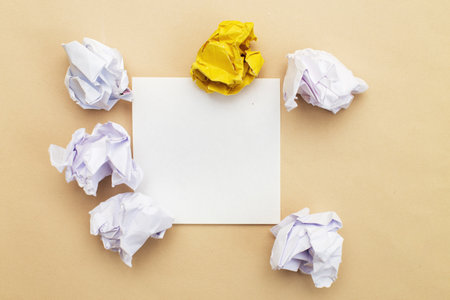 crumpled yelllow and white paper with a note to write as a concept creative idea and innovation on a beige background. Copy space for your text.の写真素材