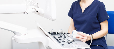 Female doctor sitting in office in a hospital doing ultrasound scanning diagnosticの写真素材