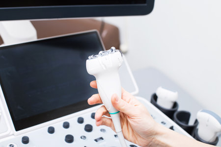 Woman doctors hand aholding a medical gel to ultrasonic sensor of ultrasound machine in the clinicの写真素材