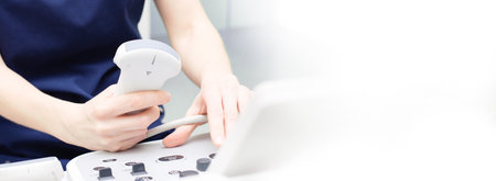 Female doctor sitting in office in a hospital doing ultrasound scanning diagnosticの写真素材