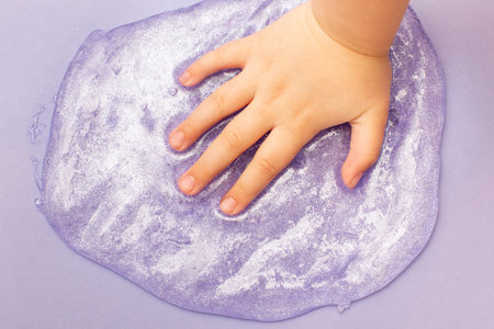 child playing with a slime at home. kid stretching colorful slime. DIY concept.の写真素材