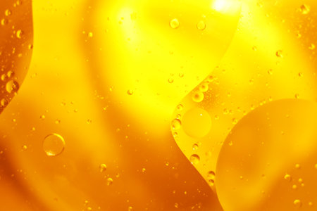 Gold Oil bubbles close up. circles of orange water macro. abstract shiny yellow background.の写真素材