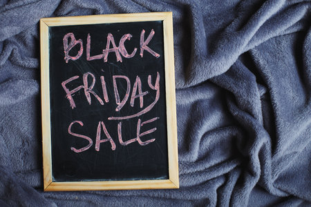 friday sale announcement on a blackboard on grey textile fabric wrinkled backgroundの写真素材